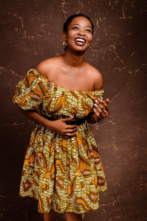 A woman in an african print dress smiling