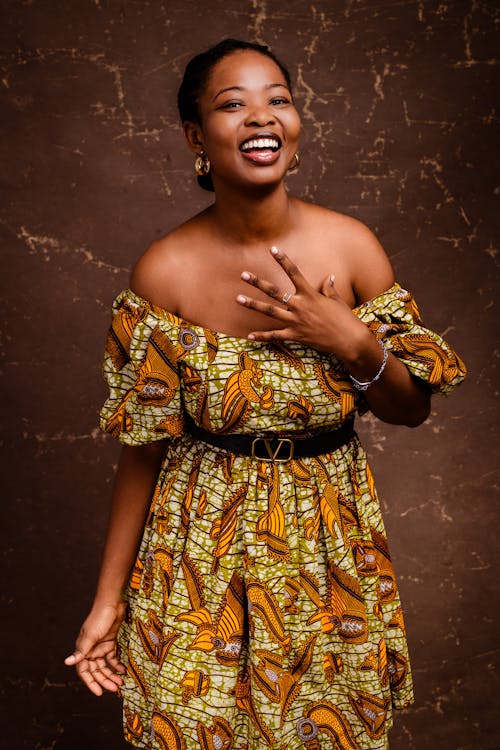 A woman in an african print dress smiling