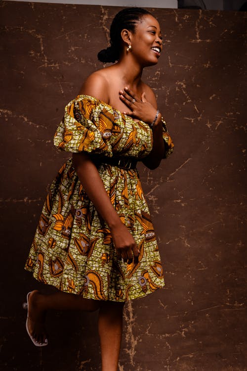 A woman in an african print dress and heels