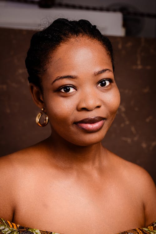 A woman with large earrings and a brown dress