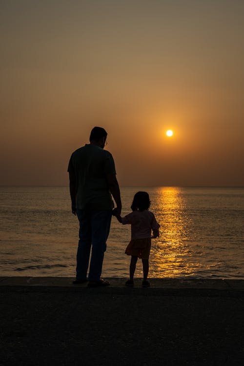 Father with Daughter on Beach at Dawn