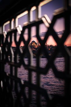 Suleymaniye Mosque in Istanbul framed by lattice at sunset, offering a picturesque view.
