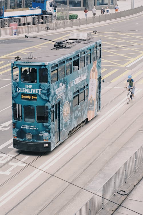 A blue double decker bus on a city street