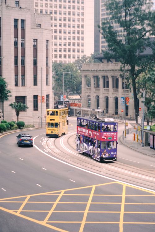 Free Vintage double decker trams traversing Hong Kong streets, showcasing urban life in the city. Stock Photo