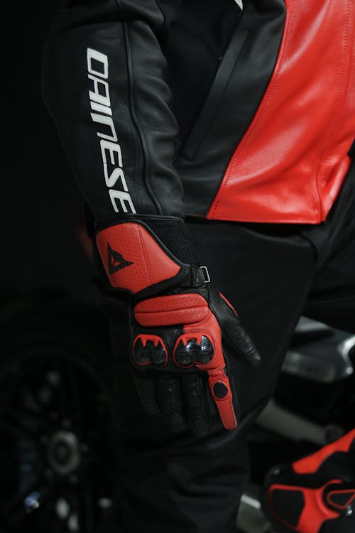 A person wearing a red and black motorcycle jacket