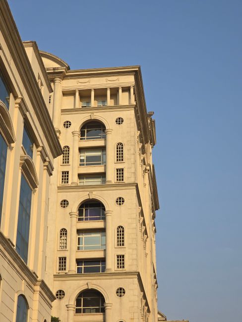 A captivating view of a tall, ornamented urban building under a clear sky.