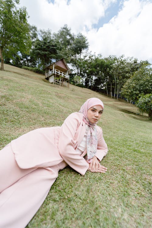 A woman in pink sitting on the grass