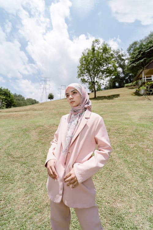 A woman in a pink suit standing in a field