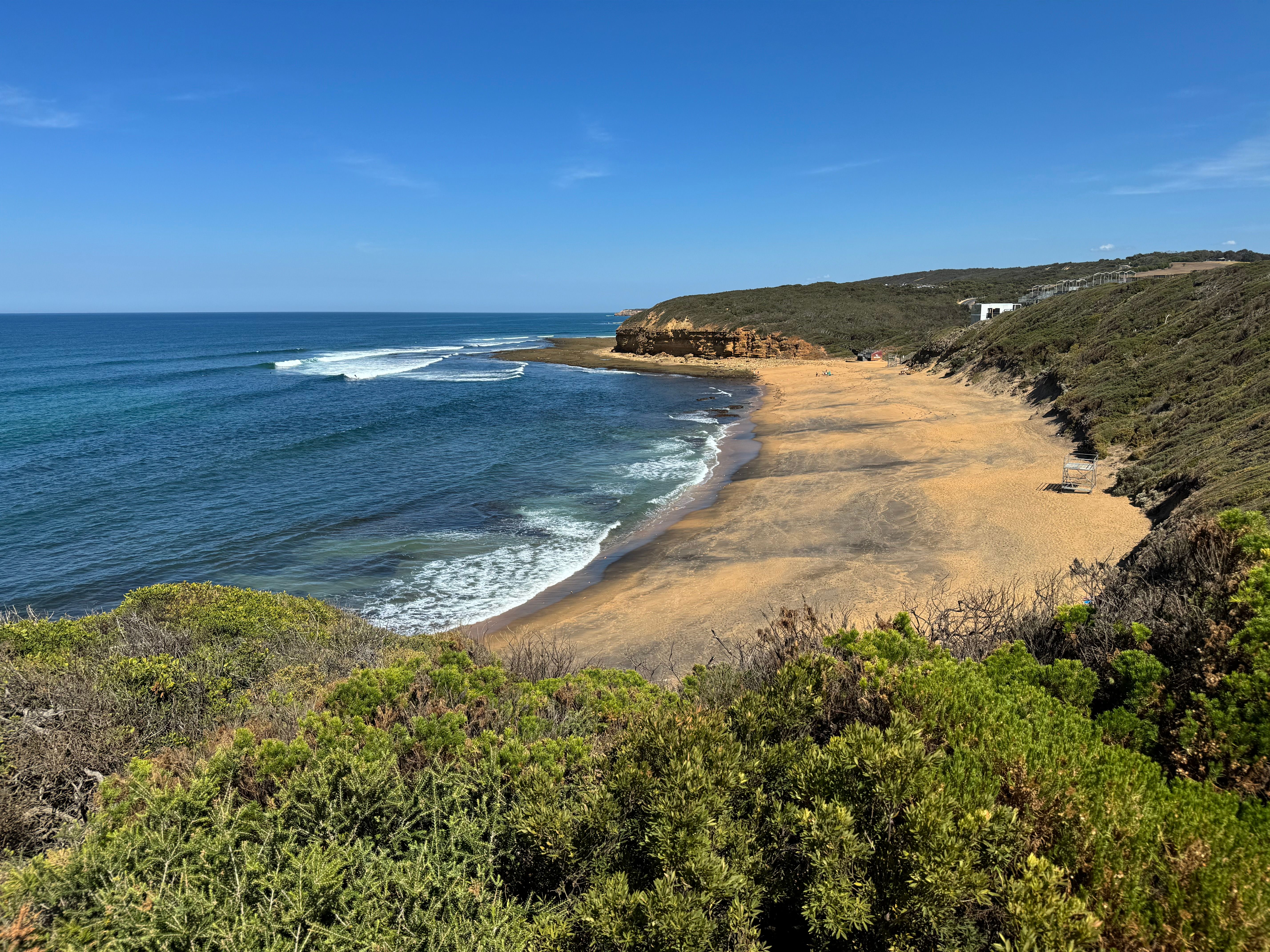 Enjoy the stunning coastline of Bells Beach with clear skies and rolling waves.