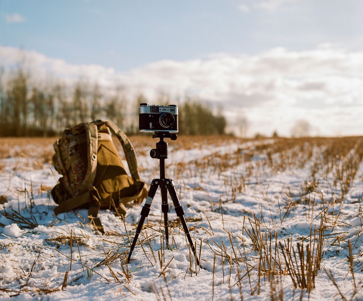 Fotógrafo usando un trípode de viaje en la naturaleza