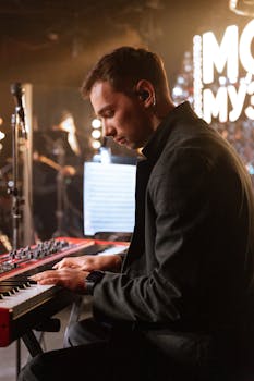 A musician engrossed in playing the keyboard during a live concert performance.