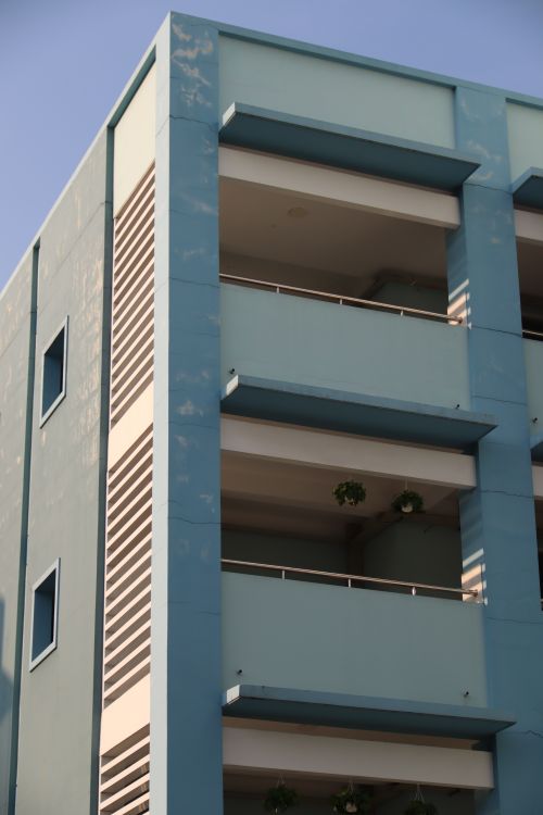 Free Close-up of a modern blue apartment building with balconies on a sunny day. Stock Photo