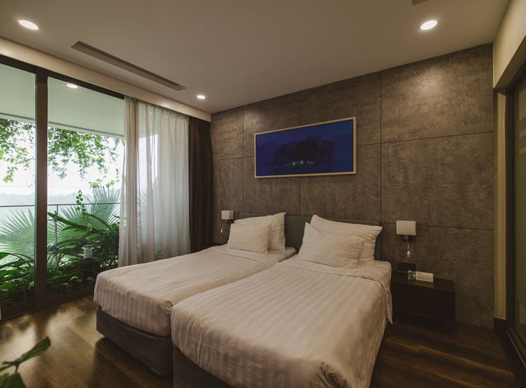 Twin garden room with linen beds and shutters open to green