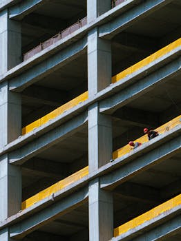 Men working on a multi-story building under construction, showcasing urban development.