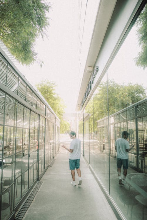 A man walking down a walkway with a cell phone