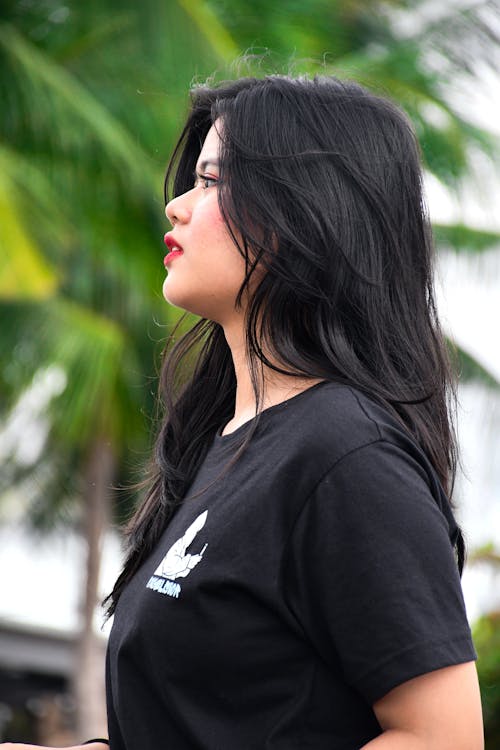 A woman with long black hair and a black t - shirt