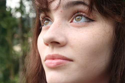 A woman with freckles looking up at the sky