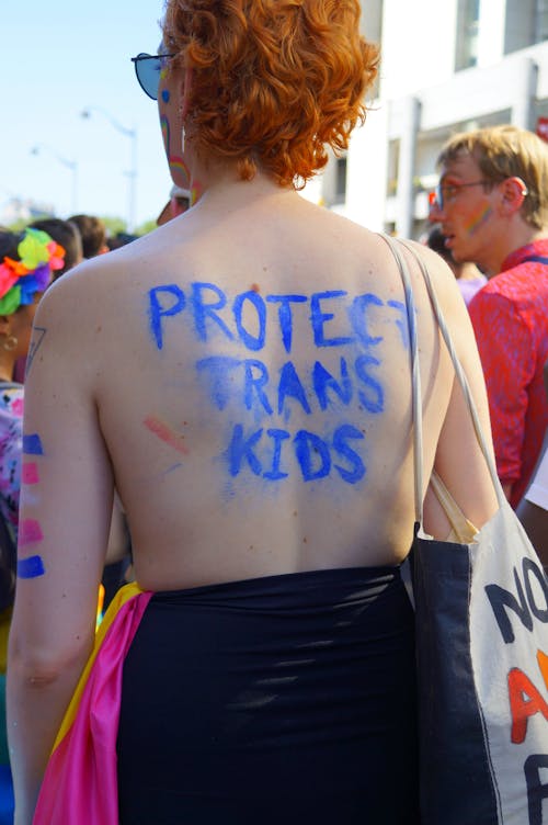 A woman with a sign that says protect trans kids