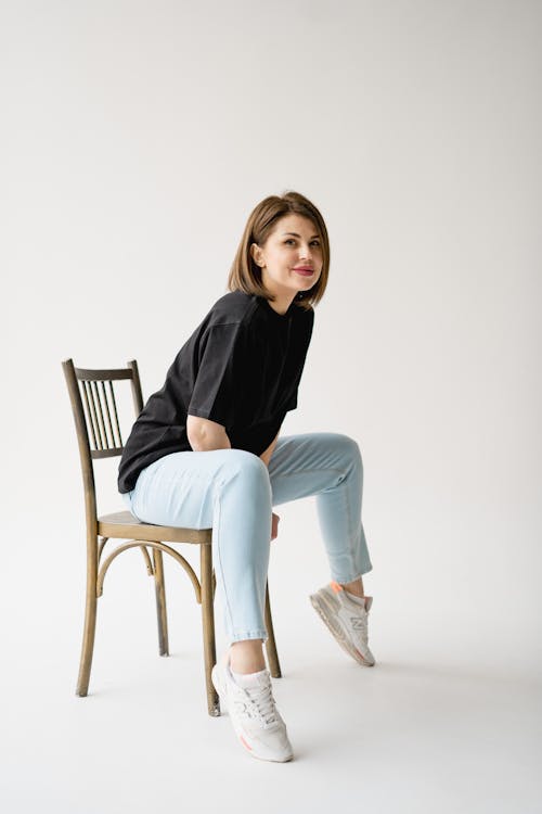 A woman sitting on a chair wearing sneakers