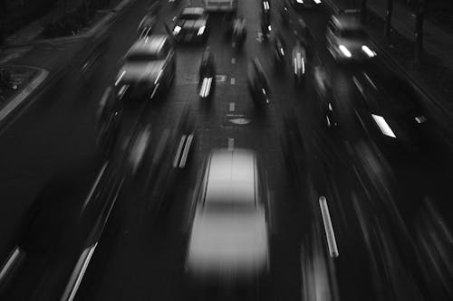 Black and white photo of cars driving on the road