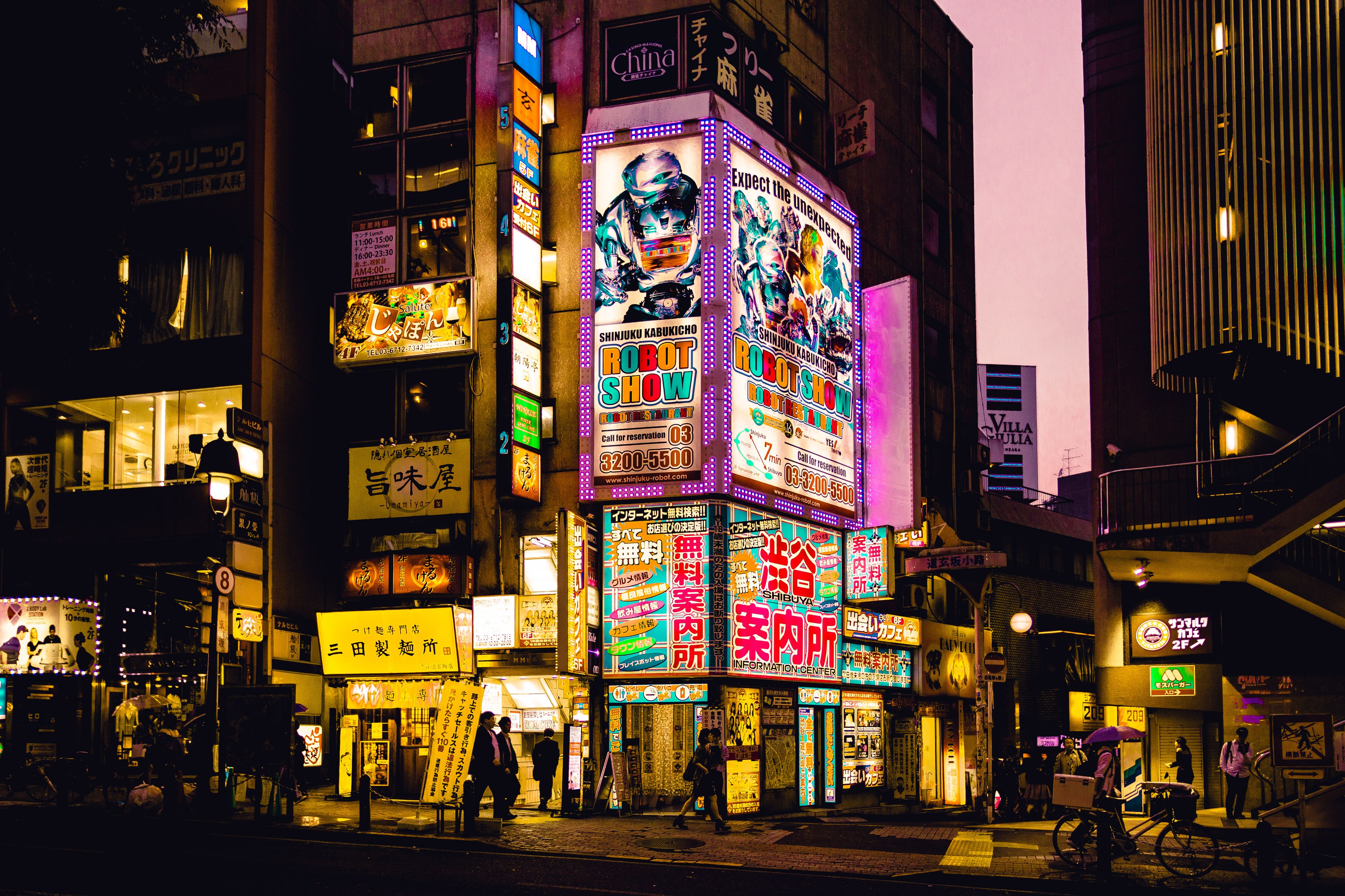 Explore the vibrant nightlife of Shinjuku, Tokyo with colorful neon signs illuminating the bustling streets.