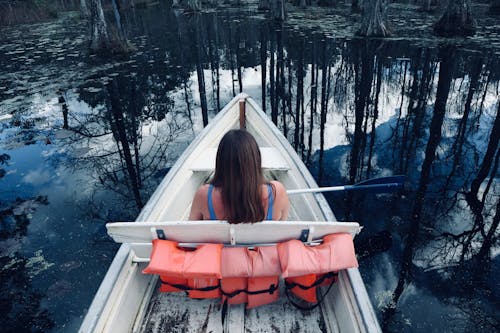 A woman is sitting in a boat on a lake