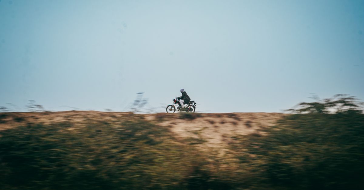 Hill View Riding Biker Riding across Hill under Blue Sky · Free Stock Photo
