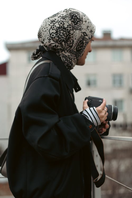 A woman with a camera and a scarf
