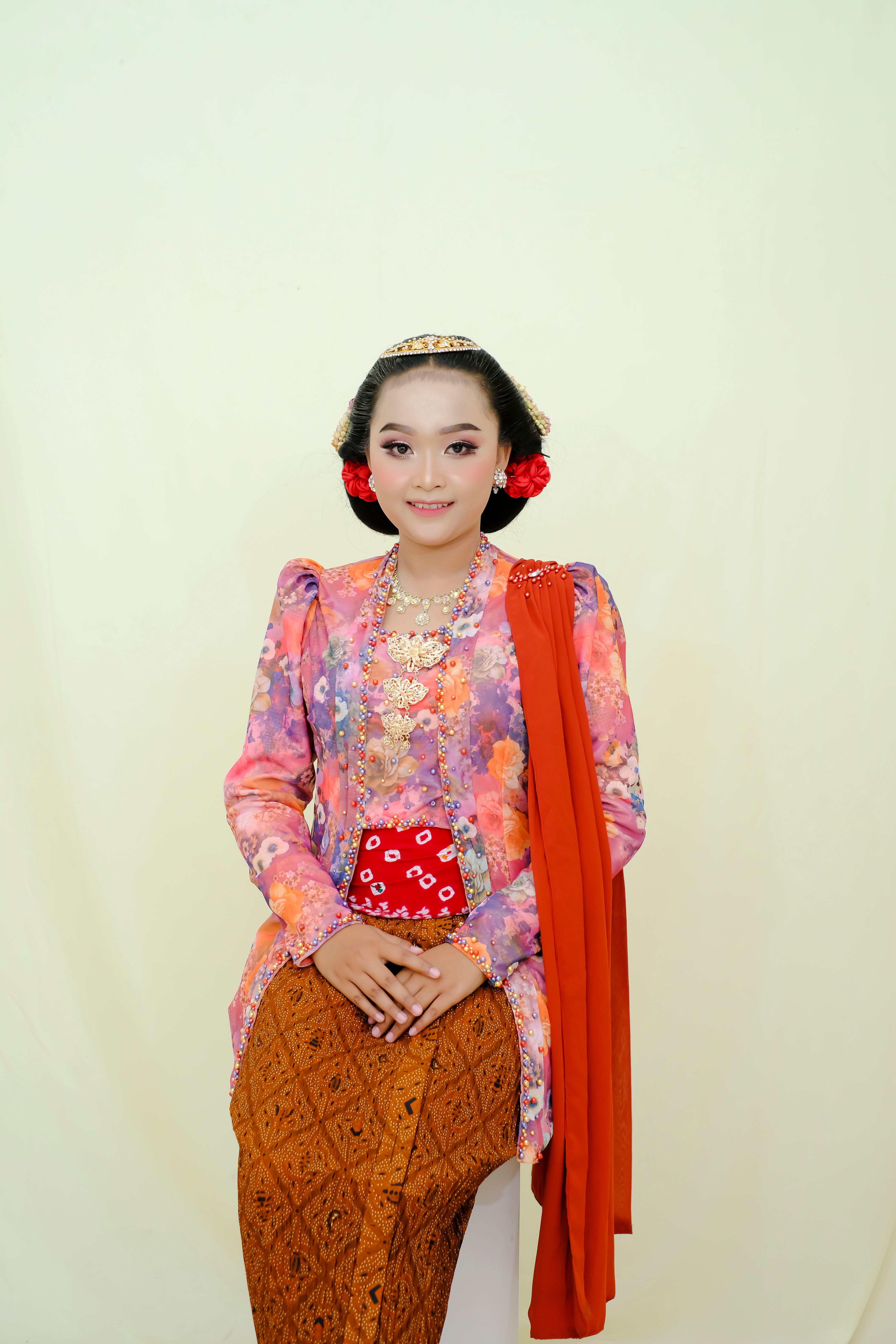 Portrait of a woman in colorful traditional Indonesian kebaya, smiling gracefully.