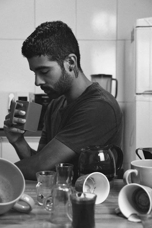 A man sitting at a table with a cup of coffee