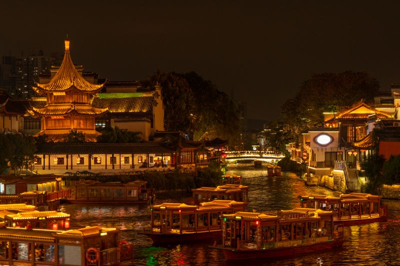Nanjing Qinhuai River at night with traditional boats and pagoda