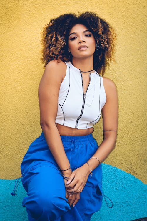 A woman with curly hair and blue pants