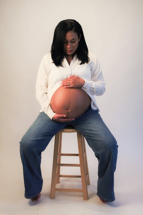 Безкоштовне стокове фото на тему «білий фон, вагітність, вертикальні постріл»