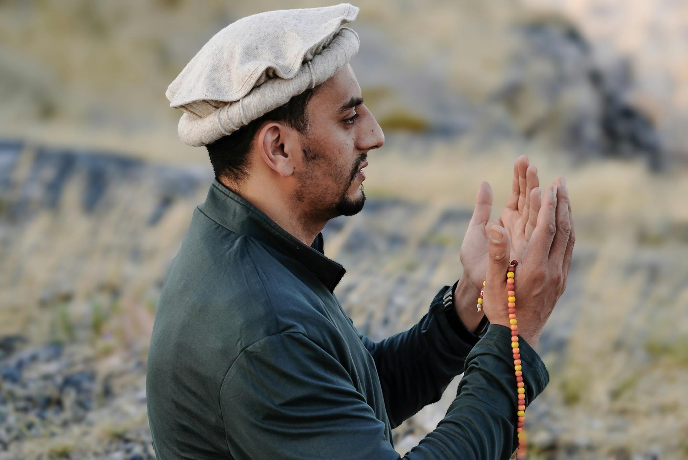 Closeup of a Man Wearing Traditional Clothing, Praying with a Rosary ...