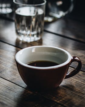 清晨，木桌上放着一杯热腾腾的黑咖啡，场景舒适宜人