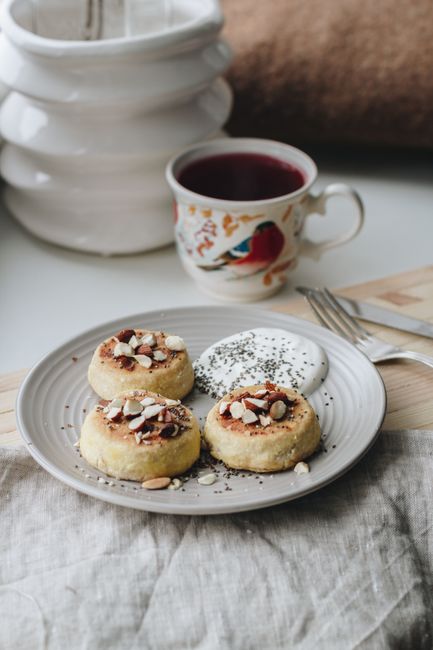 A plate of pastries with nuts and seeds, served with a cup of herbal tea.