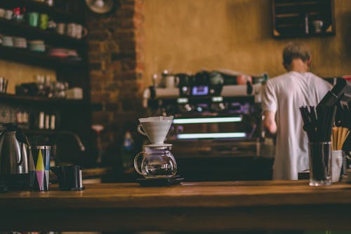Free Man Standing Beside Commercial Espresso Machine Stock Photo