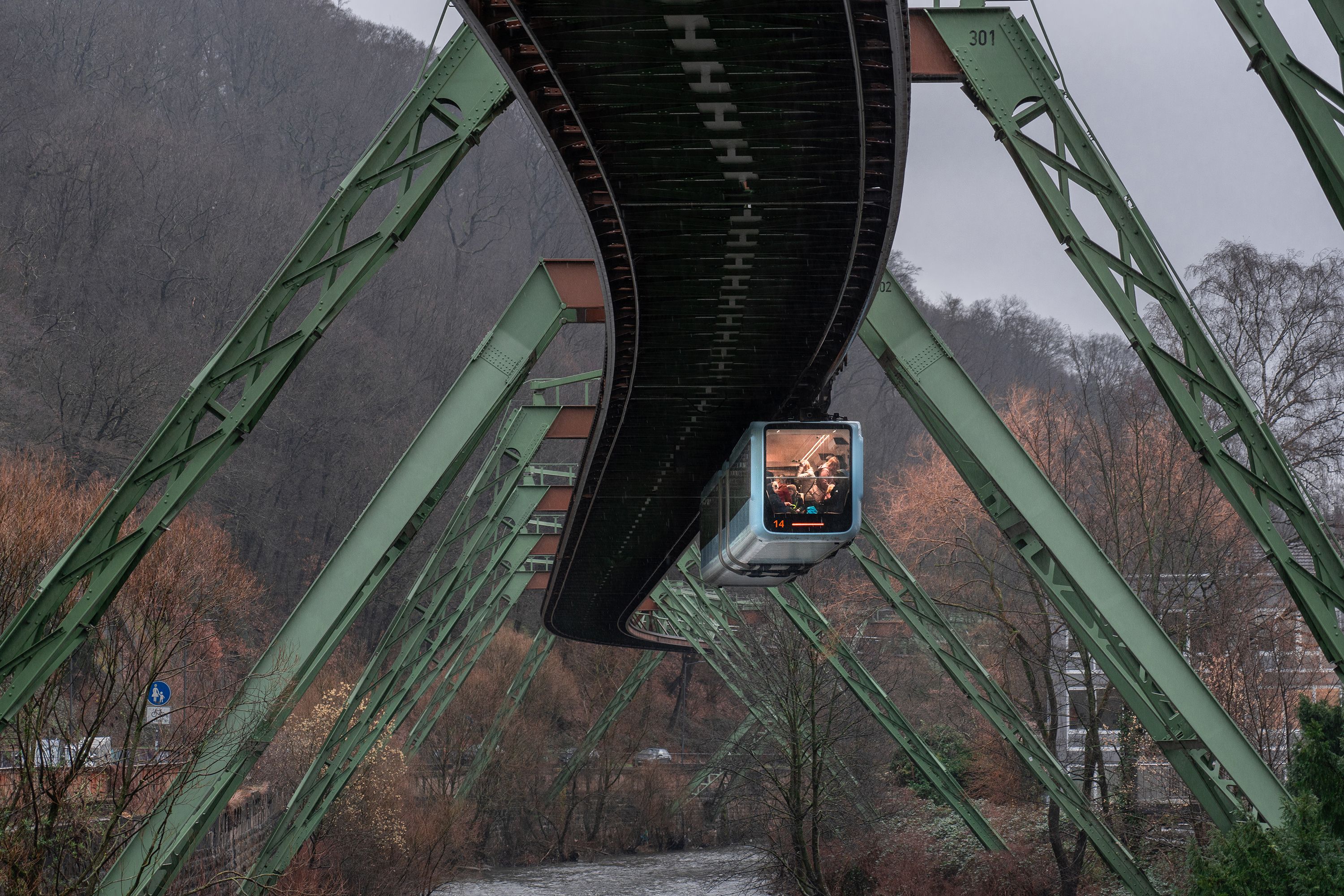 The iconic Wuppertal Suspension Monorail traversing through a scenic landscape in Germany.