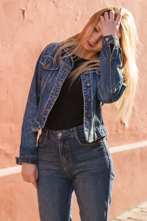 Free Woman Holding Her Head Wearing Blue Denim Jacket Stock Photo