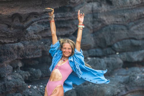 Free A woman in a pink bathing suit is standing on a rock Stock Photo