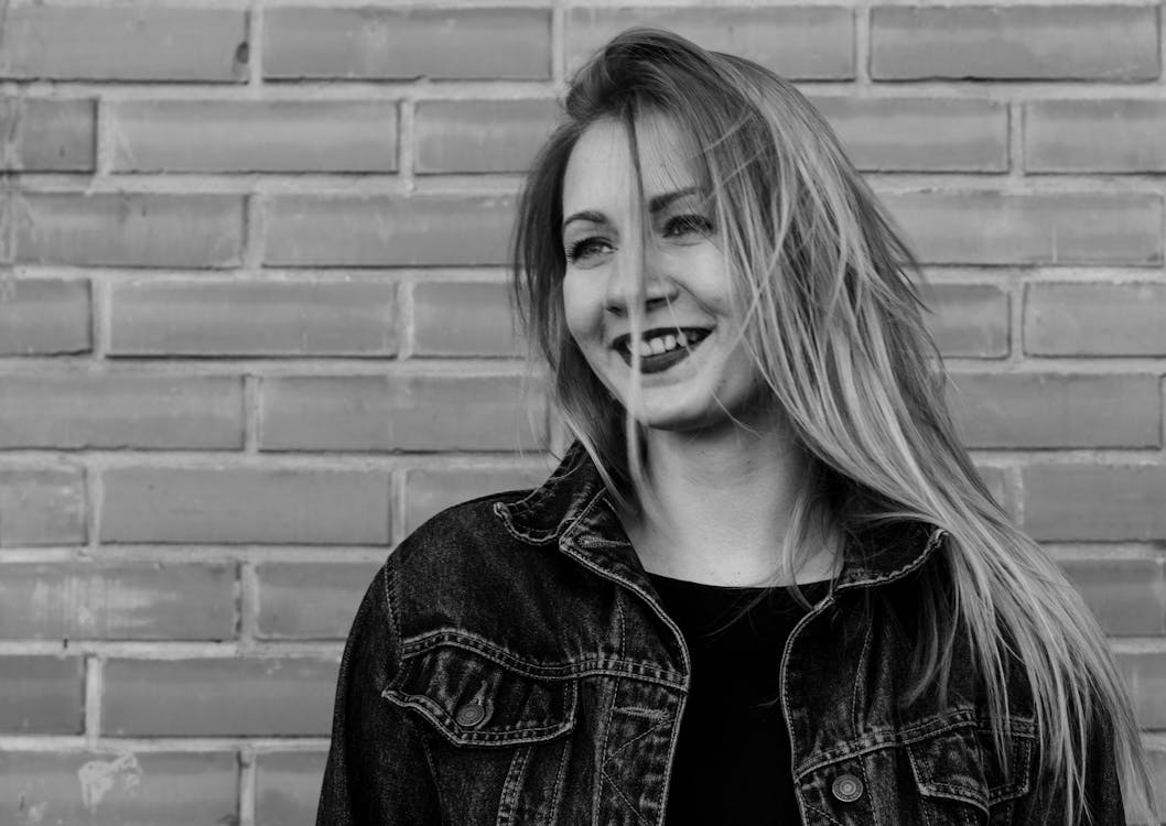 Smiling Woman Near Brick Wall