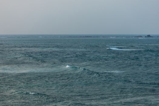 A calm sea stretching towards a distant horizon, capturing tranquility and vastness of the ocean.