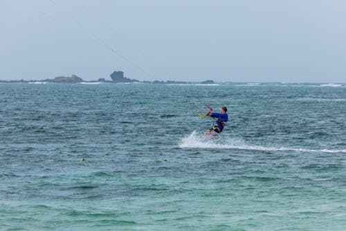 A person kite surfing in the ocean with a sail