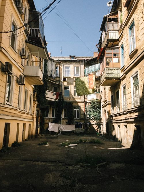Free A quaint historical courtyard surrounded by buildings with balconies, capturing the essence of classic architecture. Stock Photo