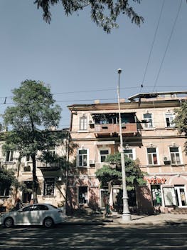 优雅的城市街景，以经典建筑和阳光下停放的汽车为特色