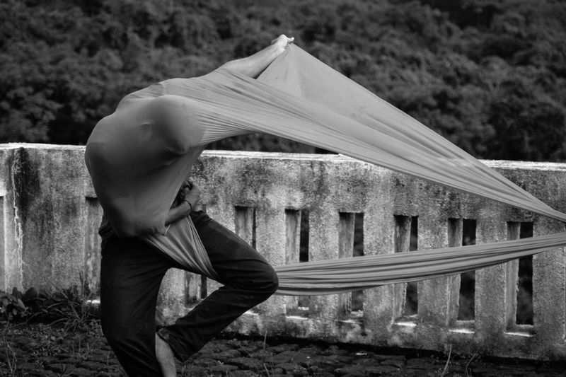 Black and white image of a contemporary dancer in dynamic motion with fabric outdoors in Mumbai.