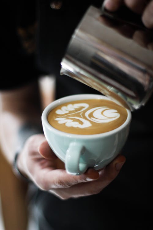 Foto Della Persona Che Tiene La Tazza Di Cappuccino