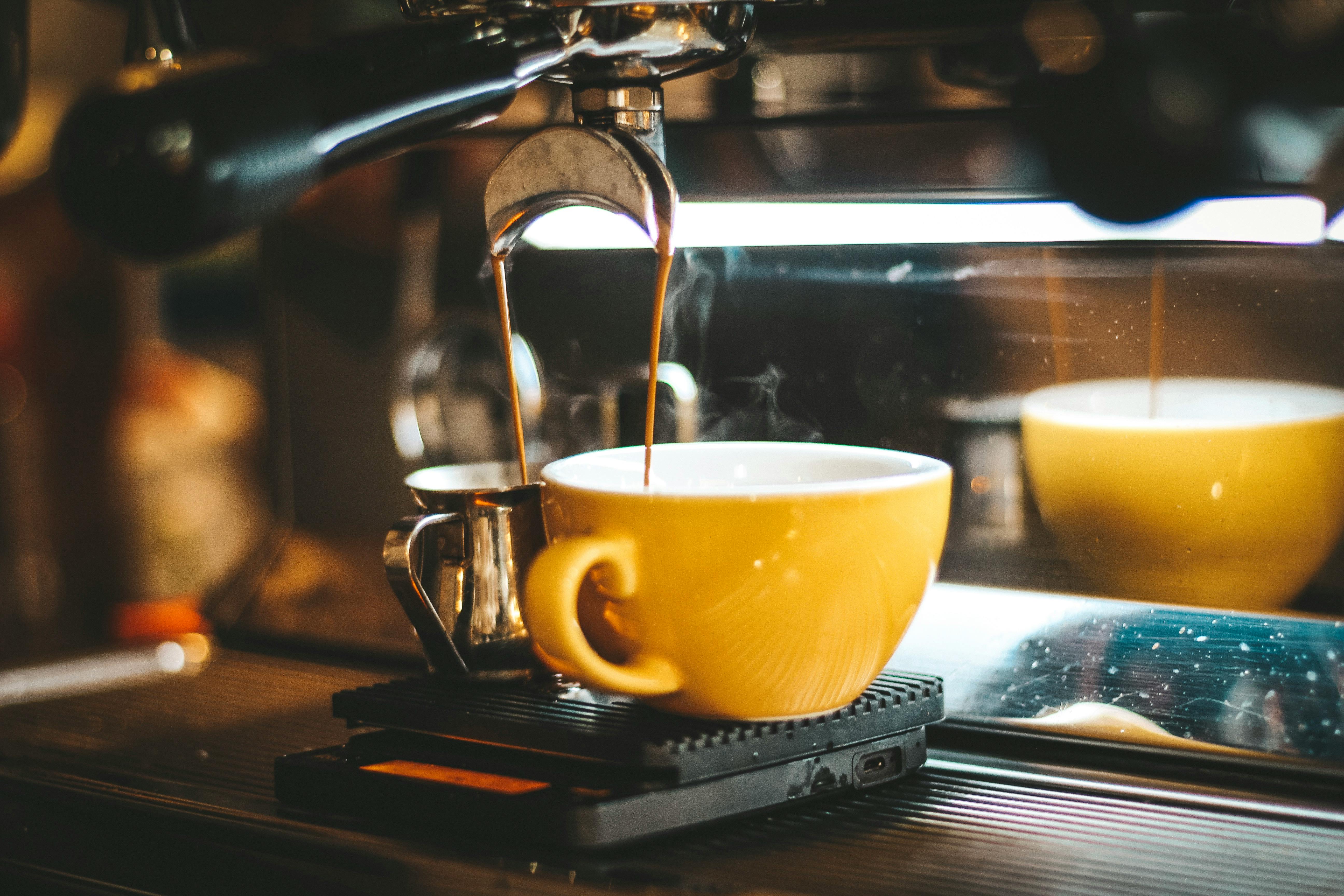 espresso machine dispensing on two mugs