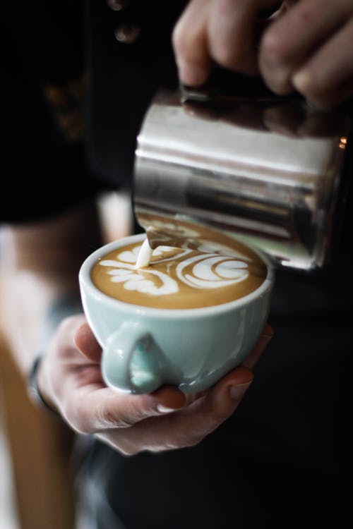 Free Person Pouring Cream in Espresso Stock Photo