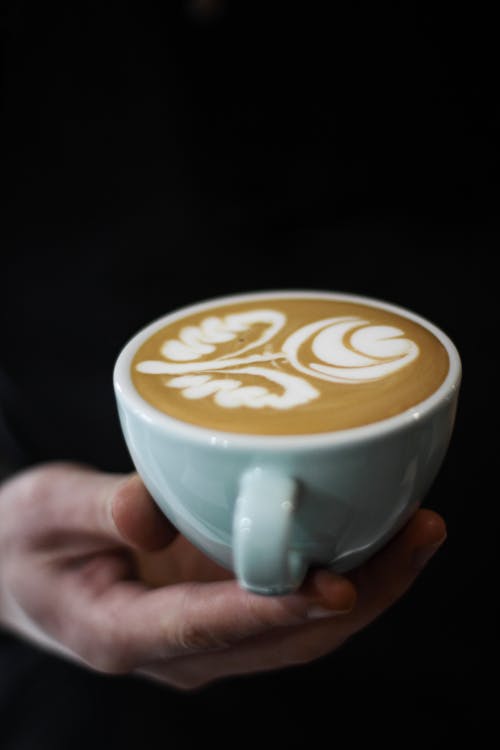 Foto Der Hand, Die Eine Gefüllte Tasse Latte Hält